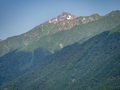 在阳光明媚的夏天，青山的山峰被雪覆盖