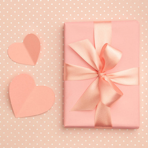 情人节的想法组成 粉红色或珊瑚礼品盒与丝带和小心脏上的活珊瑚的背景。顶部视图。扁平