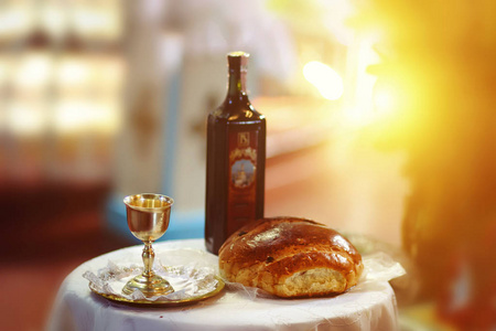 教堂木制桌子上的神圣圣餐。取圣餐。木桌上放红酒面包的杯子。基督教基督的盛宴。基督徒象征概念。
