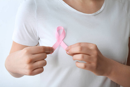 白色背景特写上有粉红色丝带的女人。 乳腺癌意识概念