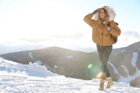 快乐的年轻女人带着背包在山里度寒假。 文本空间
