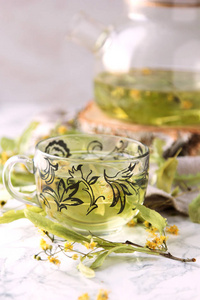 杯子和茶壶与石灰茶和干燥的石灰花。
