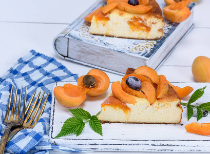 一块夹着杏子的芝士蛋糕，放在白色木板上