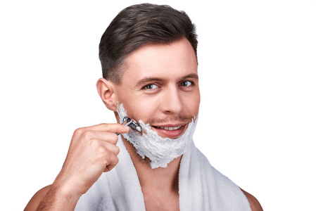 s beauty. Portrait of handsome man shaving with a razor and smil