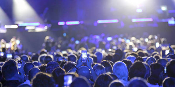 现场音乐会上的人用手机在舞台上拍照