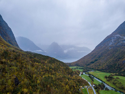 无人驾驶飞机照片的森林在挪威的山区与云覆盖山的概念，旅行和平与和谐