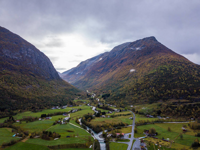 无人驾驶飞机照片的森林在挪威的山区与云层覆盖的山的概念，旅行和平与和谐