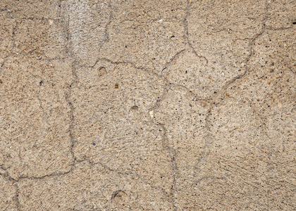 墙上有一条大裂缝的粗糙石膏。 水泥地板的质地。 背景设计用大裂缝的水泥和石膏。