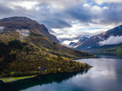 无人驾驶飞机照片的里昂在挪威的城市景观与Innvikfjorden峡湾在前景和云层覆盖大山的背景概念的旅行和和谐。