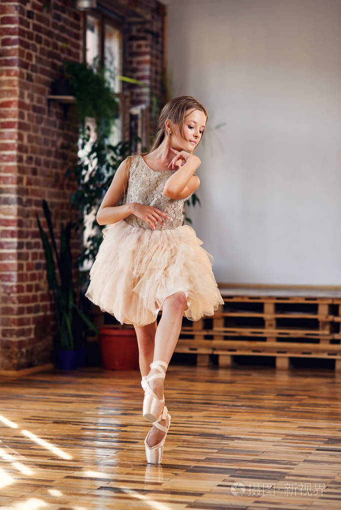 年轻的芭蕾舞演员穿着芭蕾舞鞋和尖角芭蕾舞鞋在舞厅练习舞蹈动作.