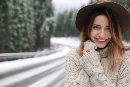 年轻的女人在户外下雪的日子里发短信。 寒假