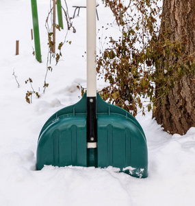 冬天的一天，塑料绿铲从一堆雪中伸出