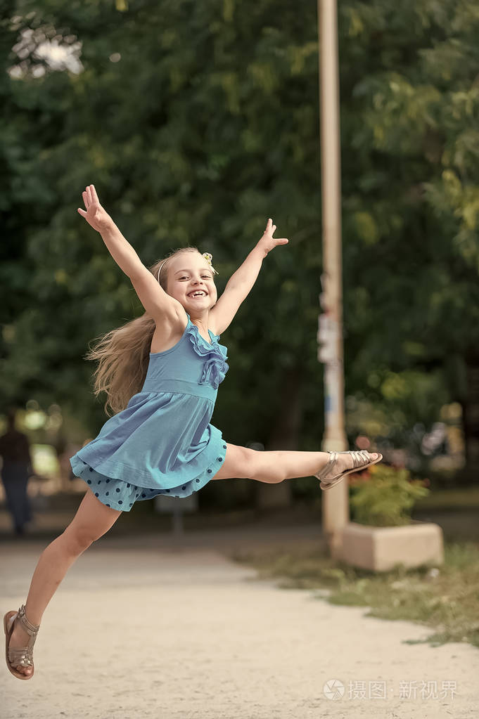 小宝贝女孩面带笑容的脸上跳跃的蓝色礼服