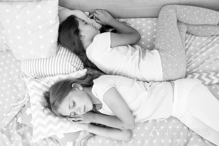 两个小女孩睡在床上的美梦.小女孩姐妹晚上睡觉