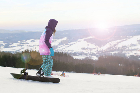 女孩滑雪者站在雪山的背景上，准备迎接回转。 冬季运动的现代体育设备。 山地度假胜地。 露天的体育活动。