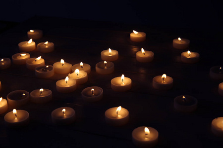 黑暗中的桌子上有许多燃烧的蜡烛