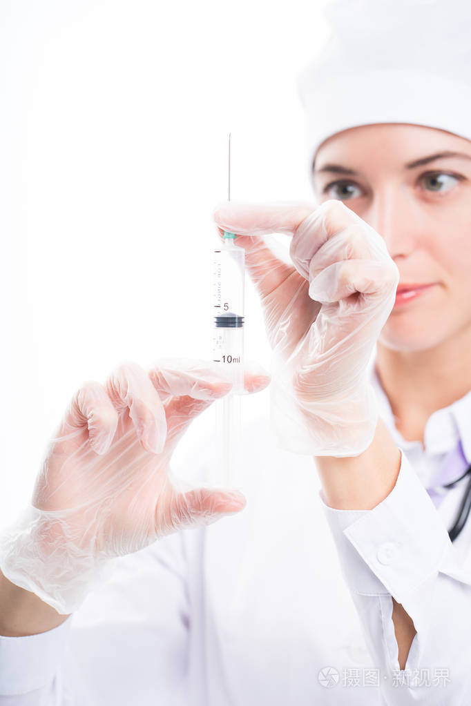 医生白色制服拿着注射器在他的手在白色背景, 并且投入针为疫苗