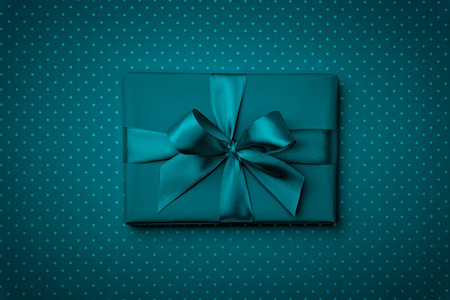 礼品盒与弓和丝带顶部视图在深蓝色或绿松石的背景。平躺着。顶视图