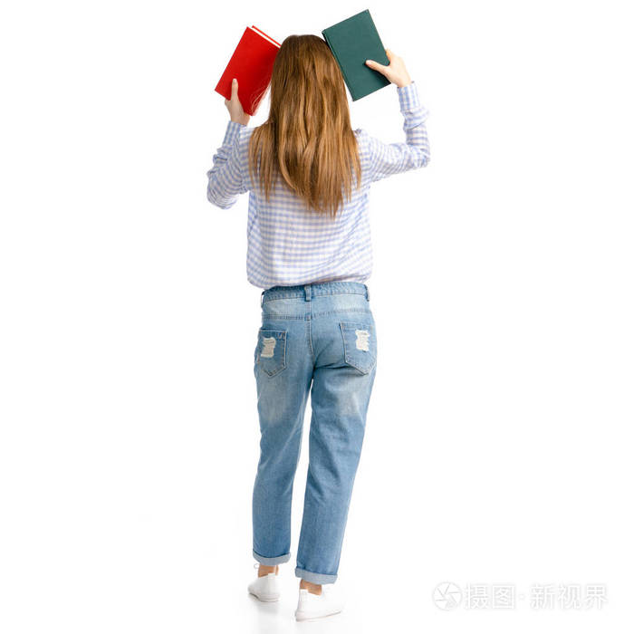 妇女在蓝色牛仔裤和衬衫与书在手