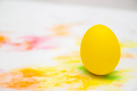 准备复活节。 在五颜六色的背景上涂上黄色的鸡蛋。 共空间。