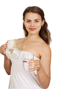 漂亮的女人拿着一壶水和一杯。孤立于白色