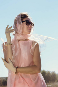 穿粉色连衣裙围巾和米色手套的漂亮女人