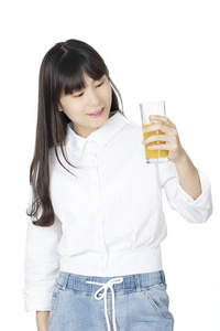 美丽的中国女人喝着白色背景的橙汁