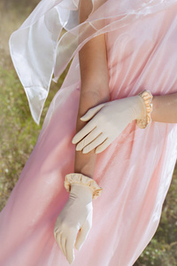 漂亮的设计师米色手套，背景是粉红色的裙子