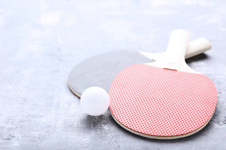 灰木桌上有球的乒乓球拍