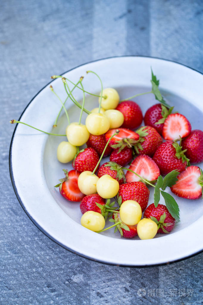 盘子里的成熟草莓和黄色樱桃
