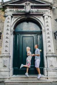 年轻漂亮的情侣女孩穿着礼服，穿着白色衬衫的男人走过意大利威尼斯的街道