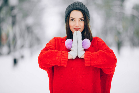 穿红色毛衣的漂亮女孩的肖像走在雪街上。