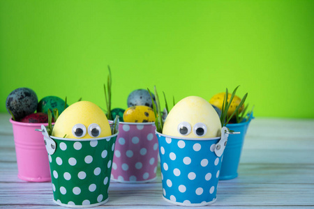 复活节背景。 有趣的复活节彩蛋在颜色背景上涂上黄色。 复活节假期的概念。 复印空间