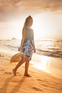 日落背景下海滩上的女孩