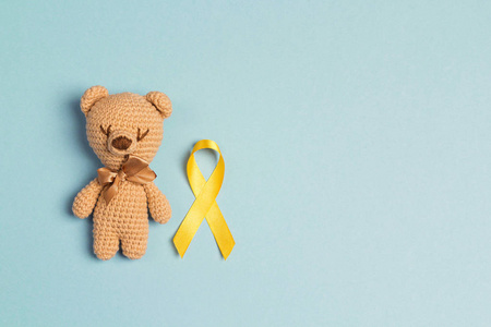 s toy with a Childhood Cancer Awareness Yellow Ribbon on blue ba