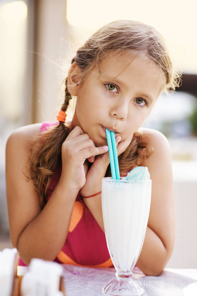 夏天,可爱的小女孩在户外餐馆喝奶昔照片-正版商用图片17myve-摄图新