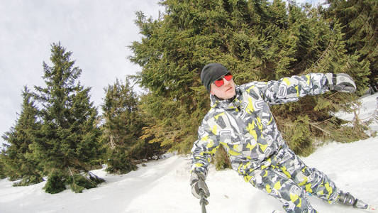 那家伙正在山上滑雪。 很多雪。 喀尔巴阡山脉。 滑雪夹克和裤子。 活跃的冬季冬天