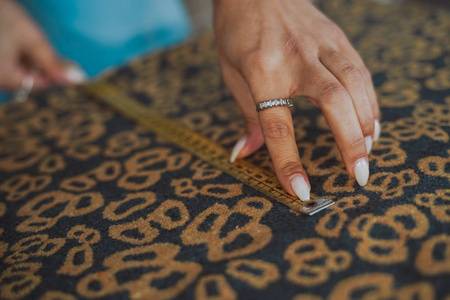 裁缝女人的手在做布料裁剪