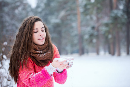 年轻漂亮的女人手中吹着雪