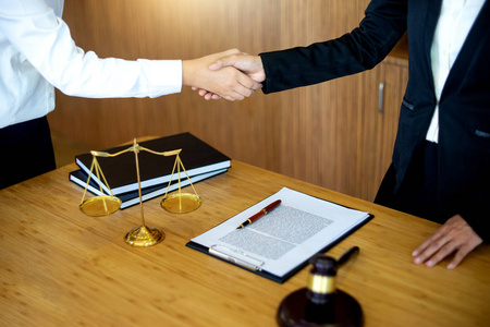 握手法律法官女槌与司法律师在律师事务所会见的背景.握手法律概念.