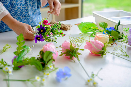 女手在花艺车间制作花卉构图..你自己做吧。