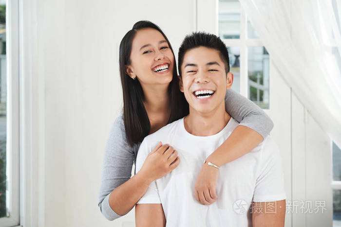 年轻欢笑的情侣拥抱看镜头的肖像照片-正版商用图片17n3z7-摄图新视界