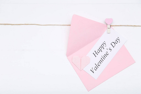 在白色背景下用信封和纸心写下情人节快乐