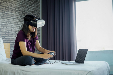 女性在家戴VR眼镜，女性在床上使用虚拟现实设备