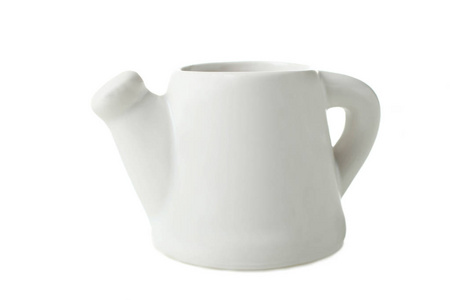 一个小陶瓷白色茶壶隔离在白色上。 概念菜。