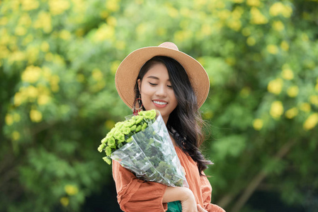 可爱迷人的年轻越南女人手里拿着漂亮的花