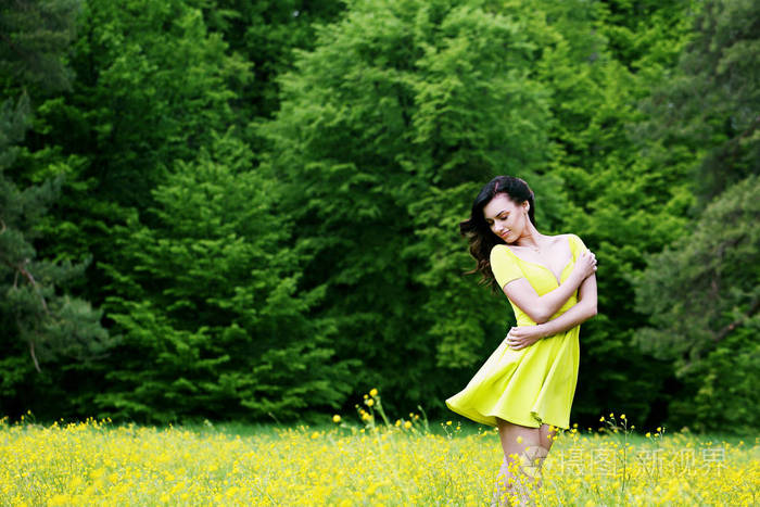 在草地上享受大自然的女人。 草地上的女孩，带着鲜花，黄油