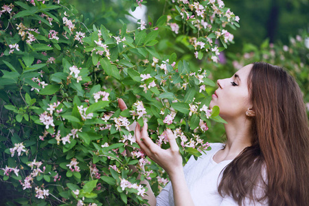 美丽的女人在春天的花园里盛开着金银花