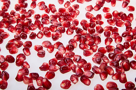 关闭石榴籽纹理在白色背景顶部视图。 成熟的红色石榴石果实