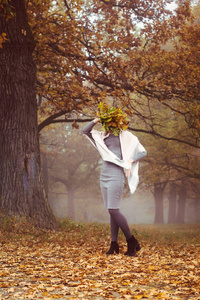 一个戴帽子的漂亮女孩走在秋天的森林里
